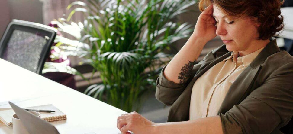 Femme stressée au bureau, représentant la fatigue liée au turnover en entreprise.